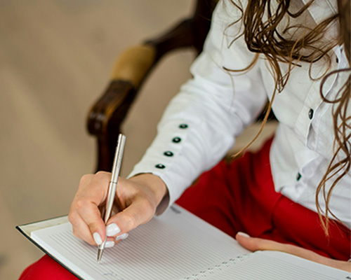 Hand schreibt Notizen in ein Heft – Symbolbild für die direkte Besprechung der HRV-Ergebnisse